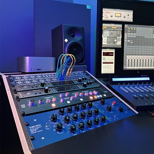 Analog equalizers and processors beside a studio monitor at That Pro Mix